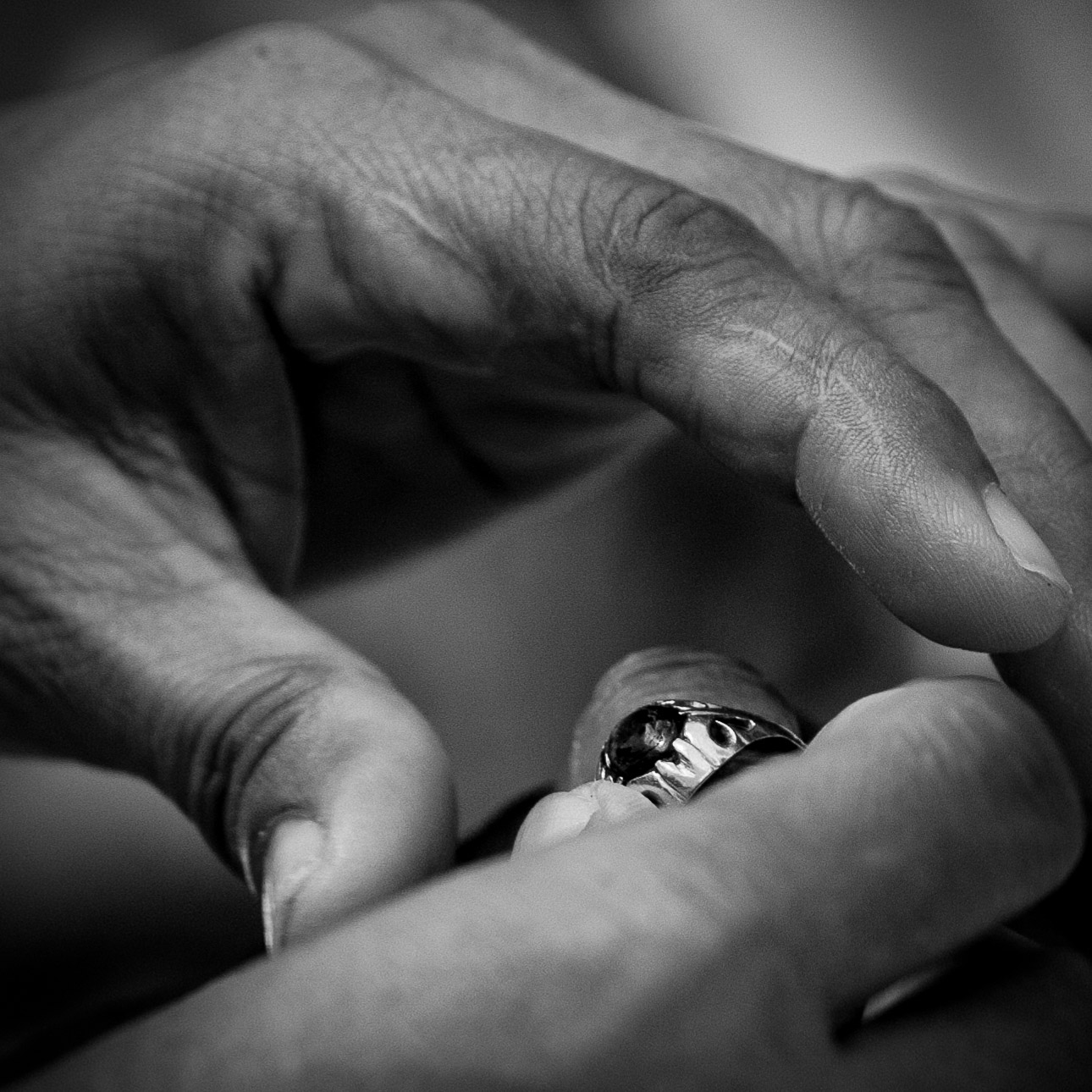 Ngaben cremation in Bali, placing a ring on the deceased man's finger during the bathing ritual.