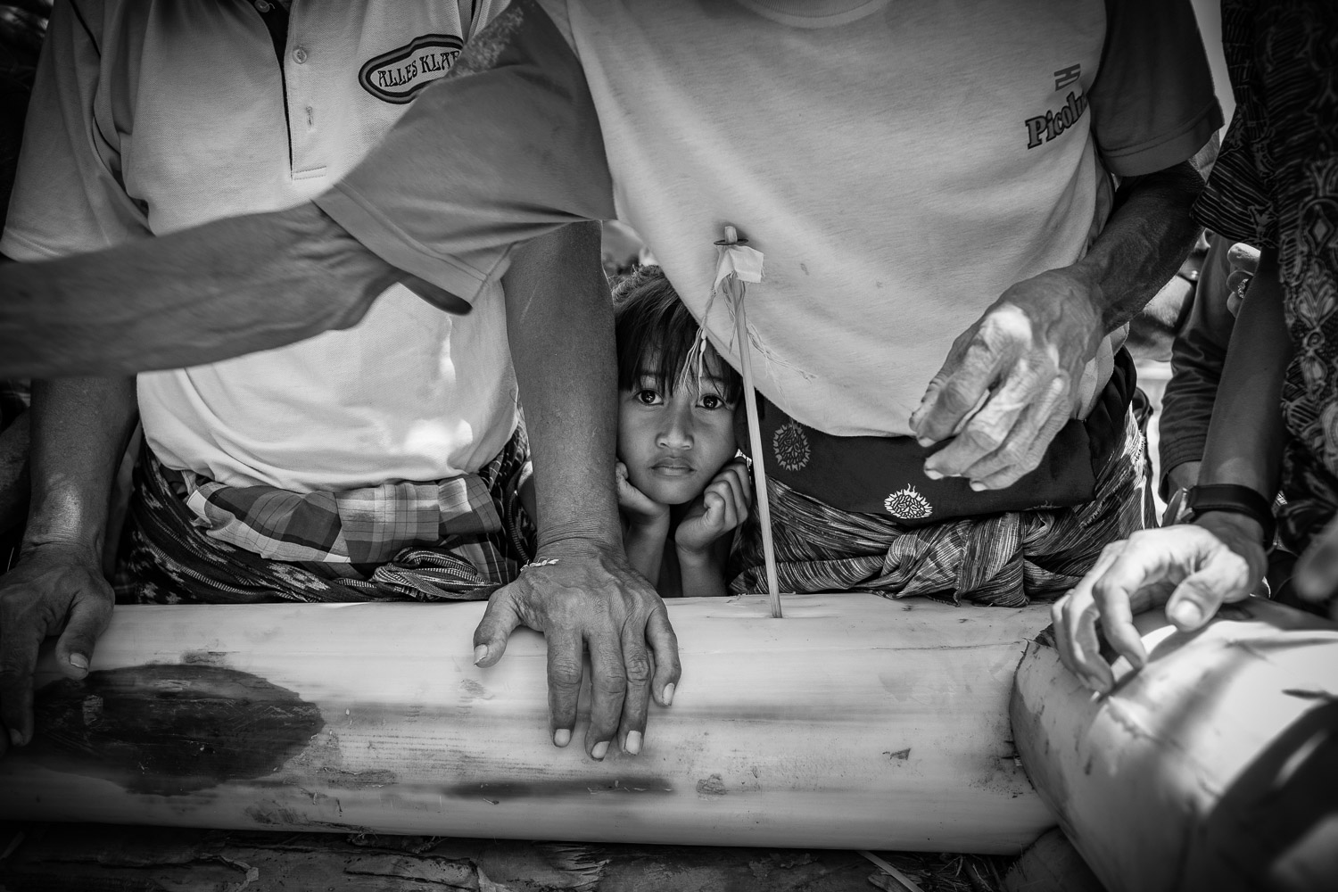 Ngaben cremation in Bali, young girl looks at the body before the fire ritual starts