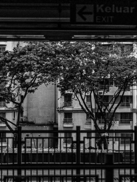 Rail platform view of an apartment block in Kuala Lumpur black and white photo taken from a rail platform