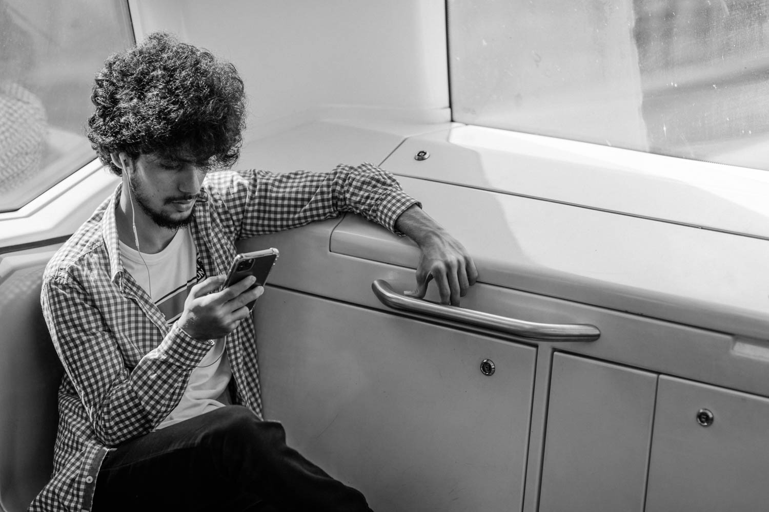 Train station photography, a male passenger on the train engaged with his mobile phone.