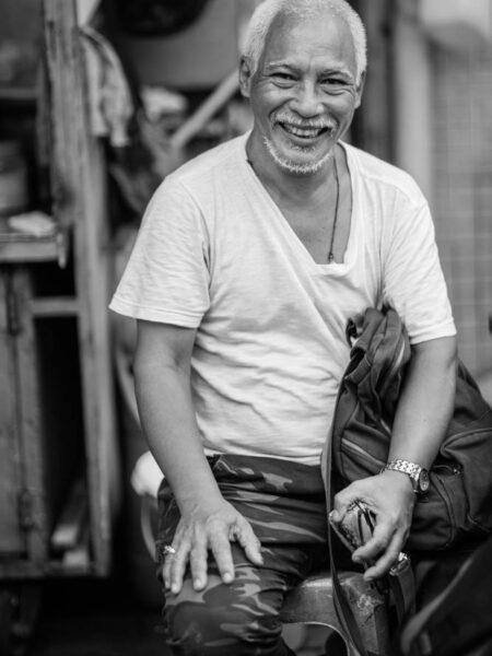 Portrait street monochrome photo of man sitting smiling kuala lumpur