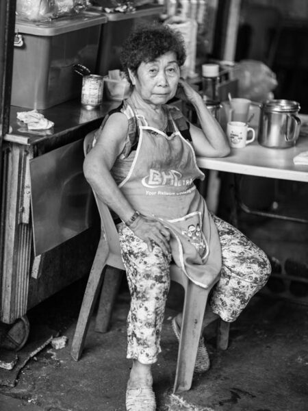 Portrait street image of a tea lady in a market in chinatown - kuala lumpur
