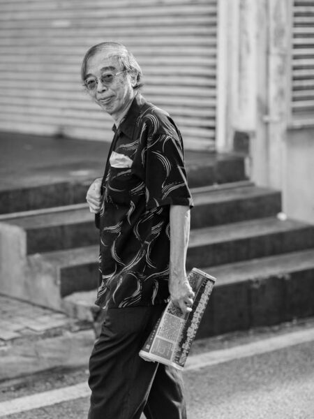 Portrait street black and white photo of man with paper in Kuala Lumpur