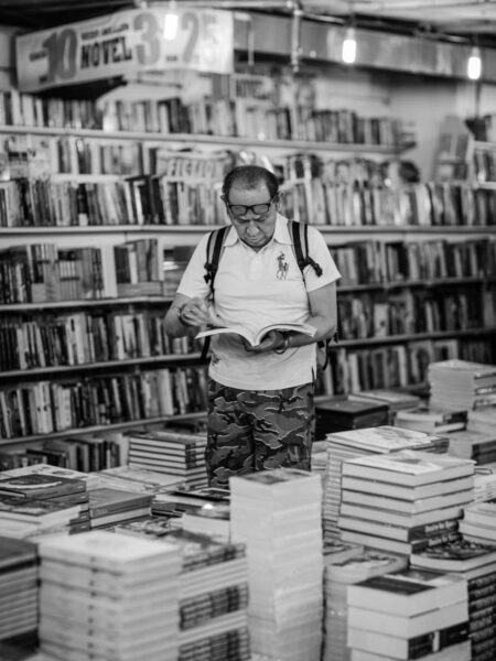 Book browsing through a book, surrounded by books in a book shop in Nu Sentral, Kuala Lumpur - Malaysia