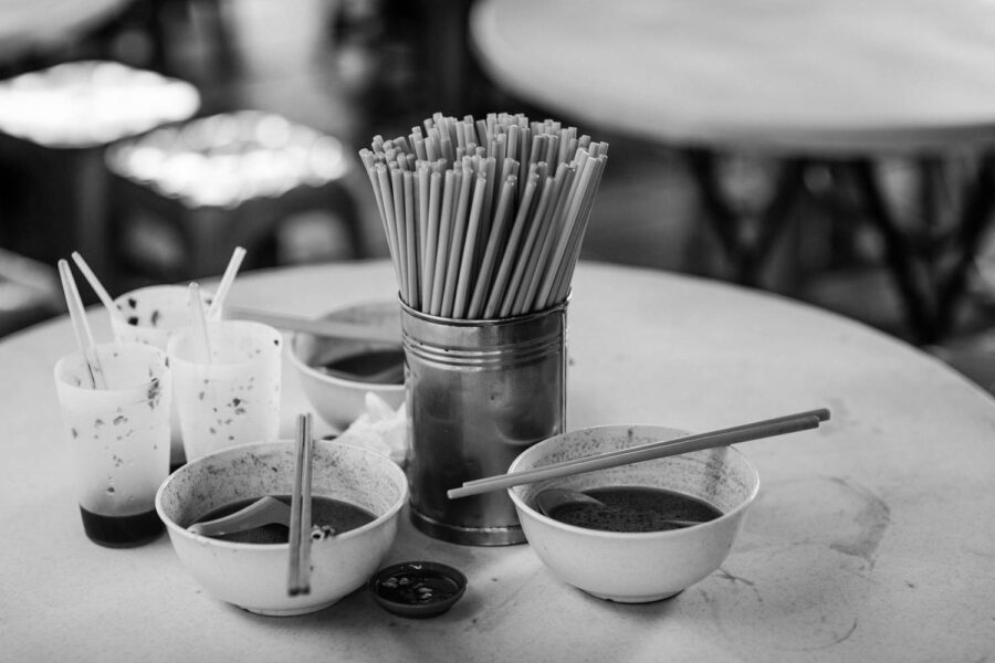 Chopsticks, and plates of leftover food at a street food stall in Pasar Seni, Kuala Lumpur - Malaysia