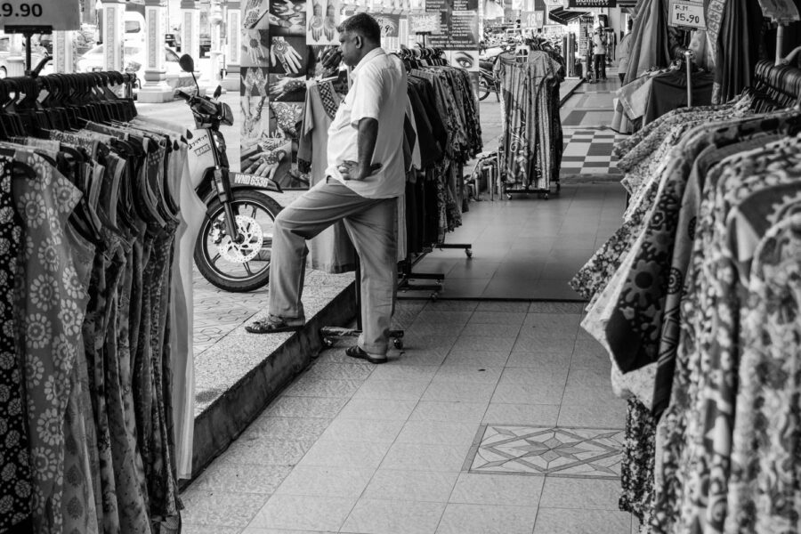 Shop assistant standing outside his shop in Little India, Brickfields, Kuala Lumpur – Malaysia