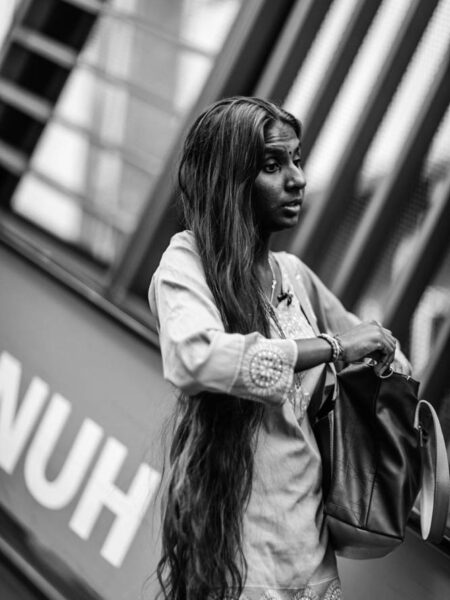 Woman with very long hair stepping off an escalator in Little India, Brickfields, Kuala Lumpur – Malaysia