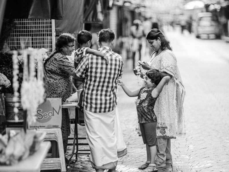 Family buying threaded jasmine flowers in Petaling Street, Chinatown Kuala Lumpur - Malaysia