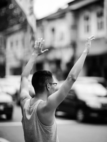 Man with arms held up above his head in Petaling Street, Chinatown Kuala Lumpur - Malaysia