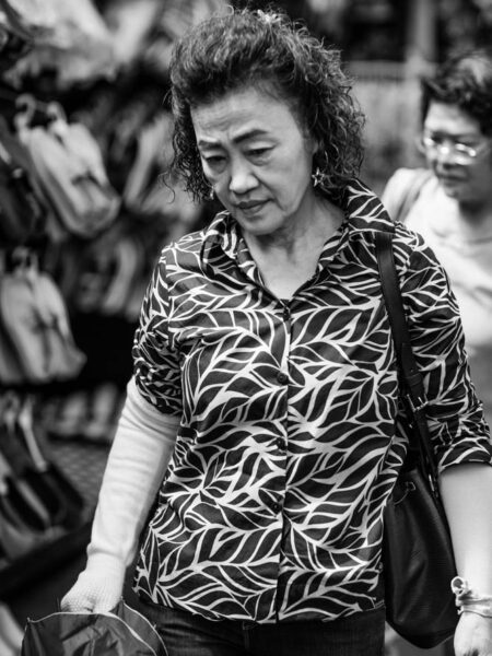 Woman walking in a colorful top, holding an umbrella in Petaling Street, Chinatown Kuala Lumpur - Malaysia