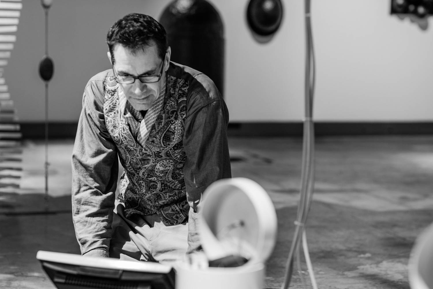 Black and white portrait photo of Ian Clothier with his Haiku Robot installation at Puke Ariki, New Plymouth New Zealand.