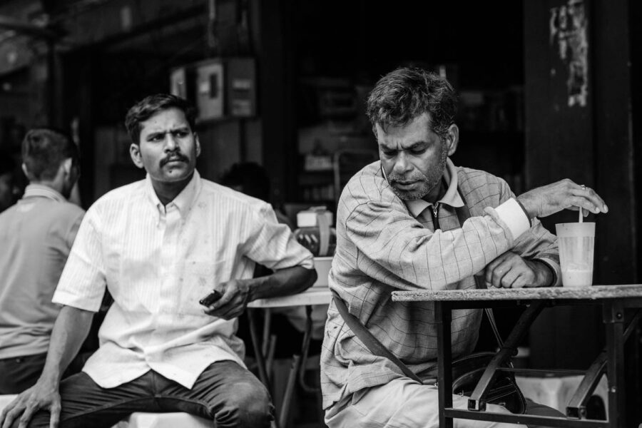 Men sitting in a cafe in Little India - Brickfields - KL - Malaysia. Black and white street portrait.