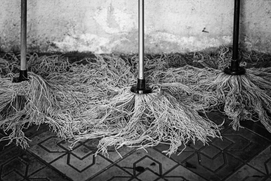 Three cleaning mops drying on the pavement in Little India, Brickfields - KL - Malaysia.