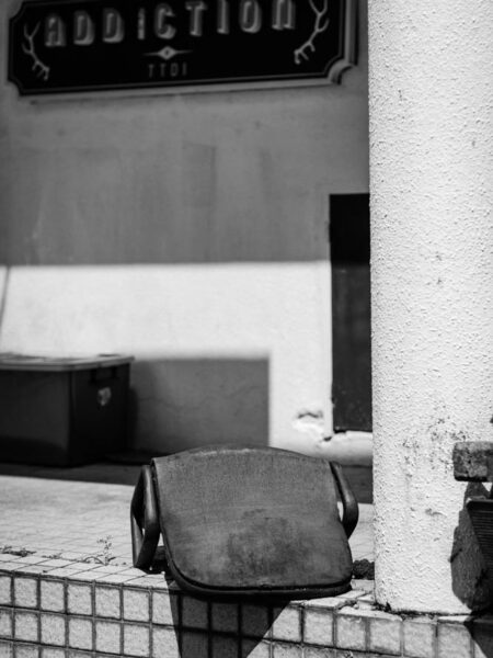 Ruined office chair outside a restaurant called Addiction in TTDI