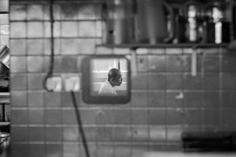 TTDI wet market man's side profile in a mirror hanging on a tiled wall - KL - Malaysia