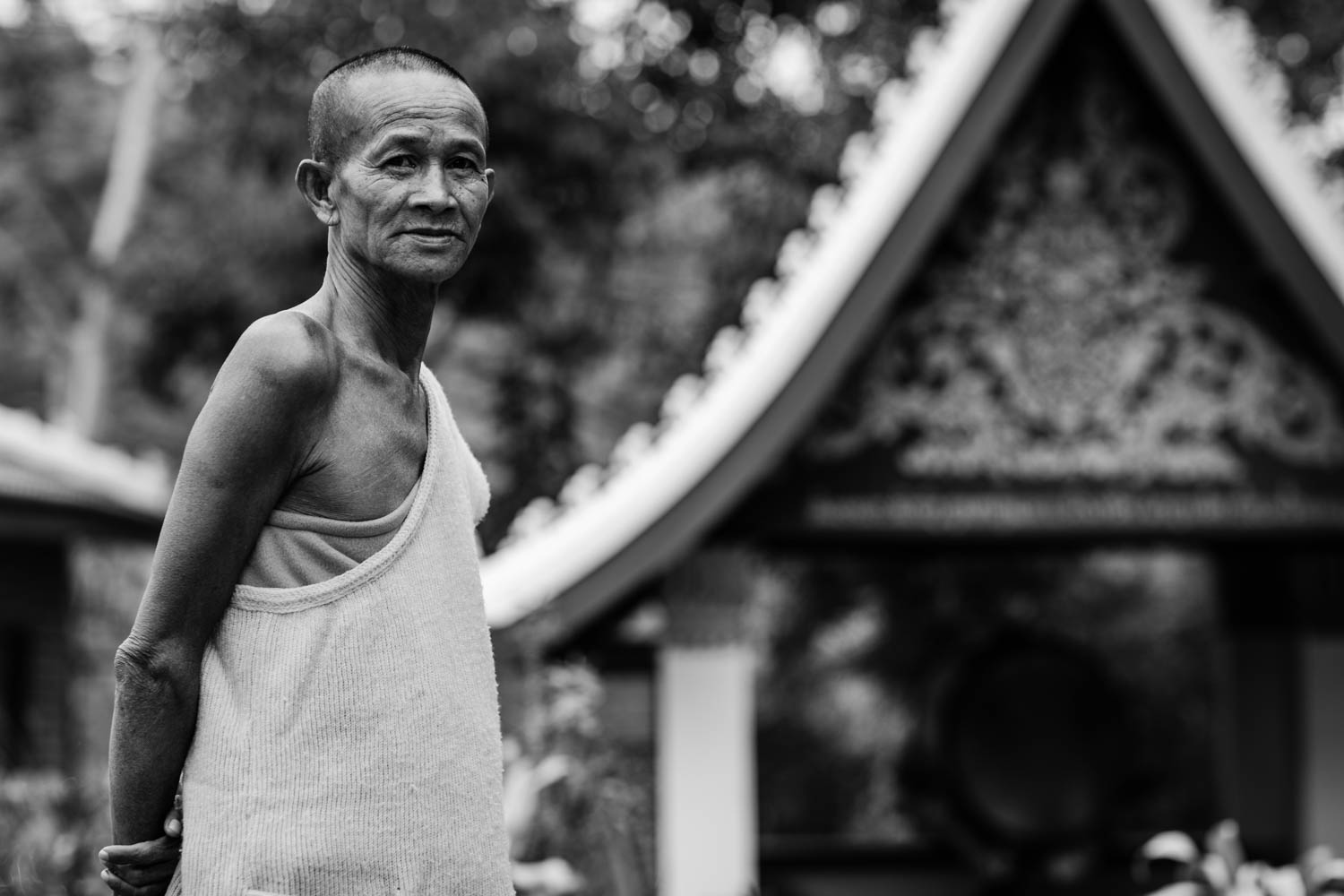 Black and white portrait of a monk standing outside Wat Chompet, Luang Prabang, northern Laos.