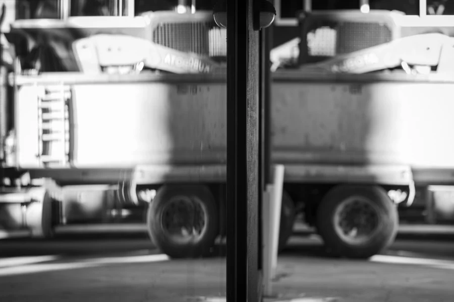 Reflection of a Mack truck with a Backhoe loaded on its tipper.