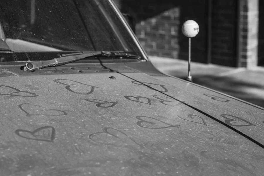 A dusty vehicle covered with hand-drawn hearts.