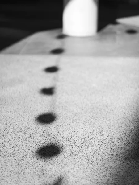 Circle-shaped shadows on the pavement in Gasworks Plaza, Newstead, Brisbane, Australia.