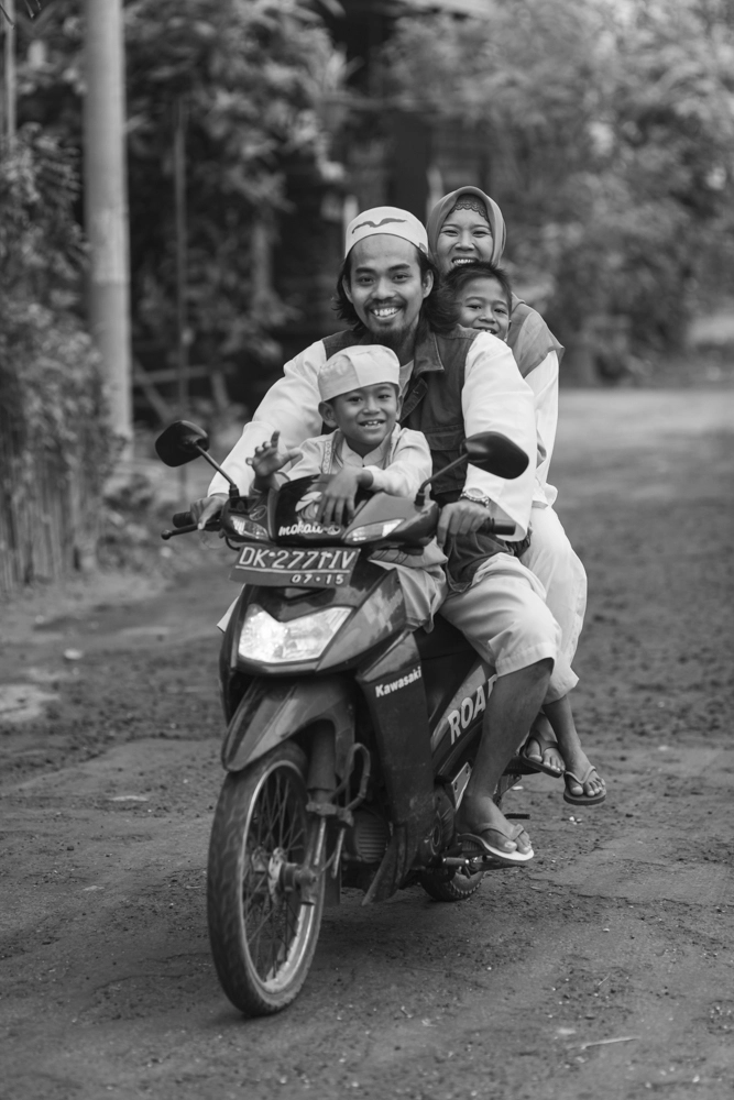 A family of four is riding their motorcycle in Jimbaran, Bali, Indonesia.