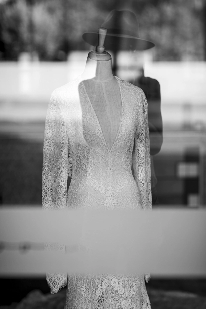 Lace bridal gown and photographer reflection.