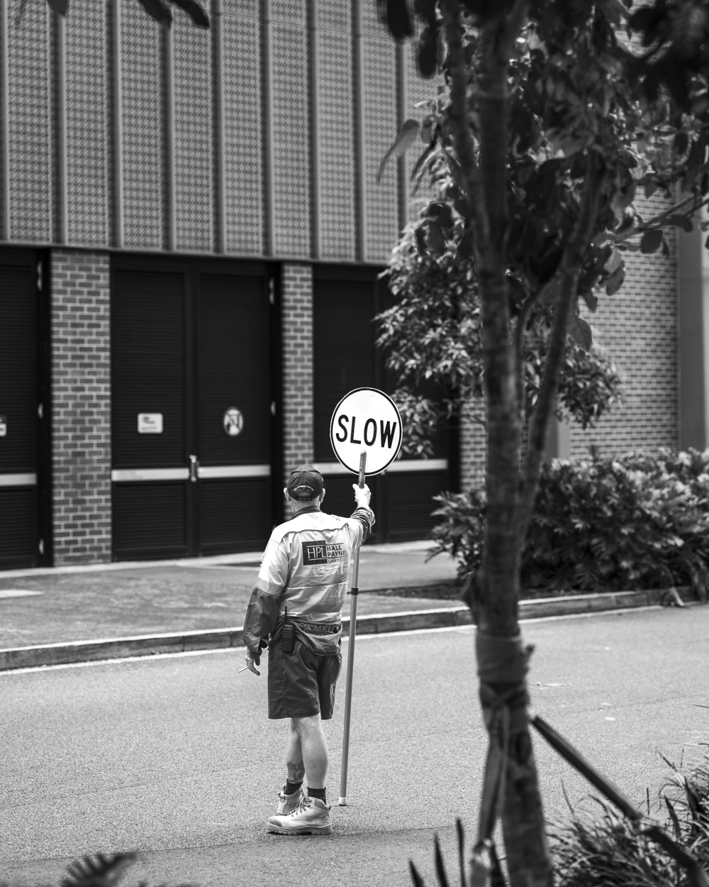 Construction worker holding a slow sign baton on Festival Street, Brisbane.