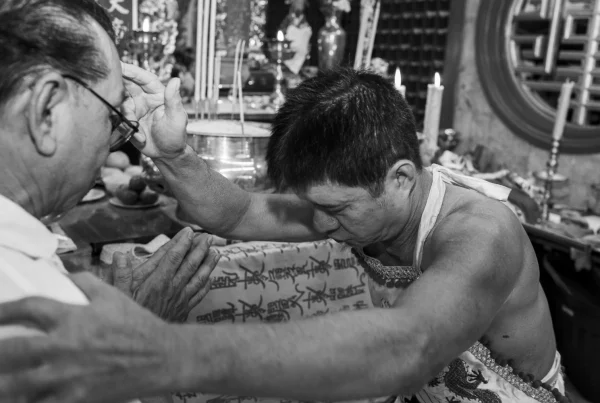 A spirit medium blessing a devotee at the Phuket Vegetarian Festival.