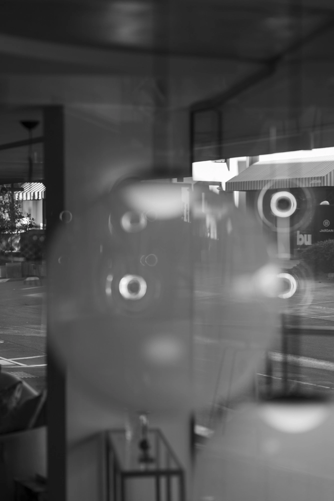Klemenza shop window reflections with circles of light, abstract street photography from Newstead.