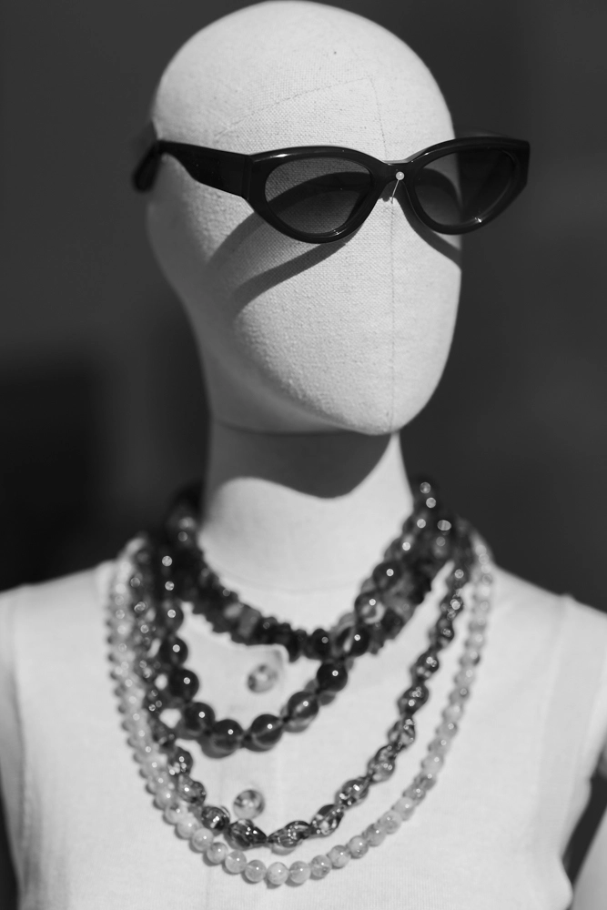 Mannequin in sunglasses and layered necklaces, Husk on James Street shopfront in black and white.